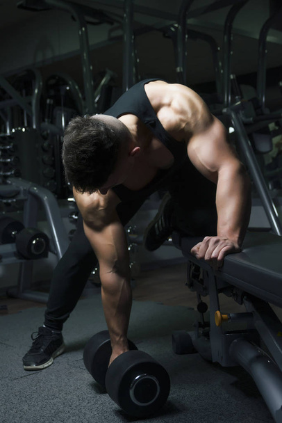 Muscular constructor hombre entrenamiento su cuerpo con dumbbell
 - Foto, Imagen