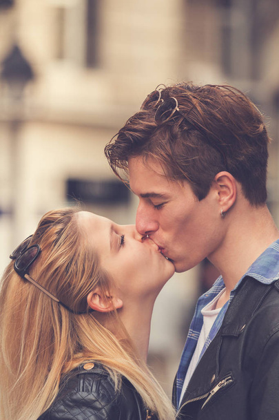 νεαρό ζευγάρι στην αγάπη τρυφερά φιλιά στο δρόμο - Φωτογραφία, εικόνα