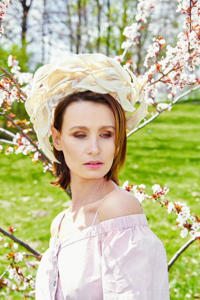 Gorgeous young woman in elegant headdress posing outdoors  - Foto, Imagem