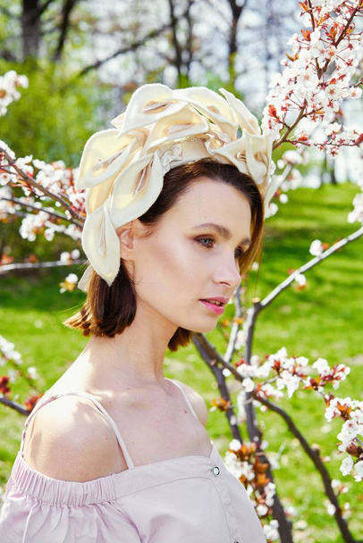 Gorgeous young woman in elegant headdress posing outdoors  - Foto, Bild