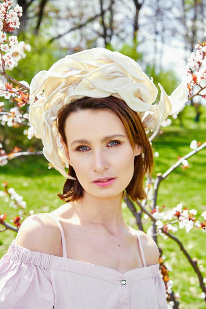 Gorgeous young woman in elegant headdress posing outdoors  - Photo, image