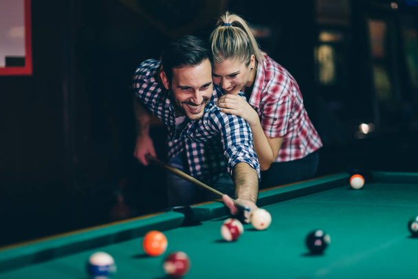Young attractive couple playing snooker together in bar - Foto, immagini
