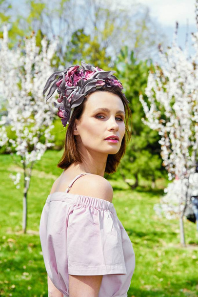 Gorgeous young woman in elegant headdress posing outdoors  - Photo, Image