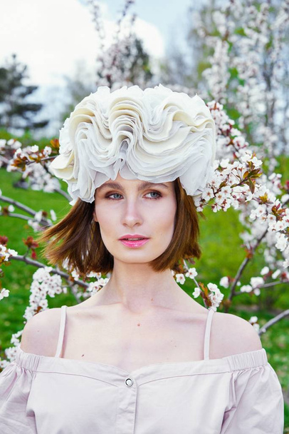 Gorgeous young woman in elegant headdress posing outdoors  - Foto, imagen