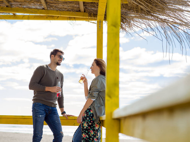 Couple Drinking Beer Together in empty beach bar during autumn time - Foto, Bild