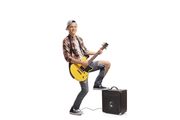 Full length portrait of a teenager playing an electric guitar isolated on white background - Foto, immagini