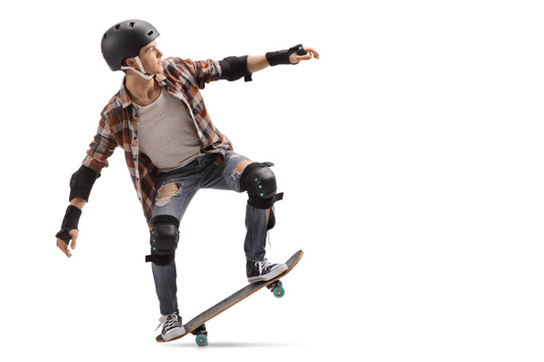 Full length profile shot of a teenage skater performing a manual isolated on white background - Φωτογραφία, εικόνα