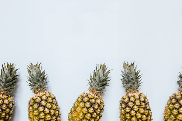 Het grenskader van de rijpe ananas op witte achtergrond geïsoleerd. Lege ruimte voor tekst, kopiëren, belettering. Minimalistische trendy stijl concept. - Foto, afbeelding