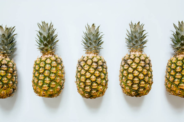 Five ripe pineapples on white background isolated. Minimalist trendy style concept. - 写真・画像