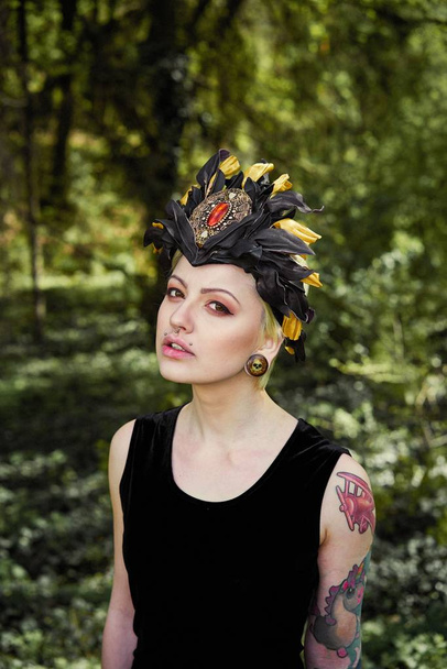 Gorgeous young woman in elegant headdress posing outdoors  - 写真・画像