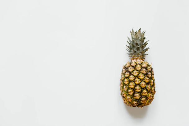 Ripe pineapple on white background isolated. Minimalist style trendy tropical concept. Room for text, copy, lettering. - Photo, Image