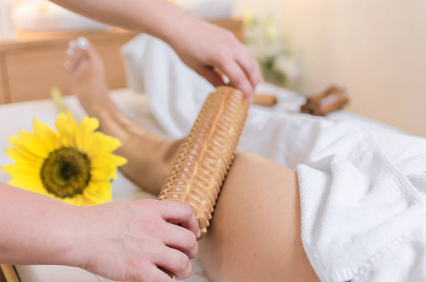 Close up of woman during spa anti cellulite massage with wooden rolling pin for anti cellulite - Foto, immagini