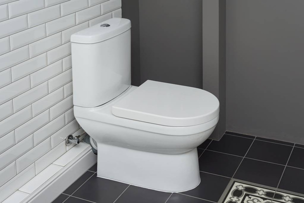 White ceramic toilet bowl in the bathroom interior close-up. - Fotó, kép
