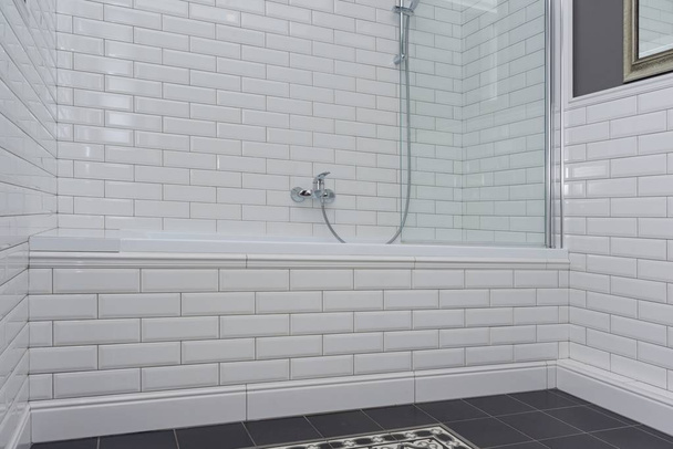 Bathroom interior close-up. The walls are painted gray, covered with decorative ceramic tiles with white glossy bricks - Foto, Bild
