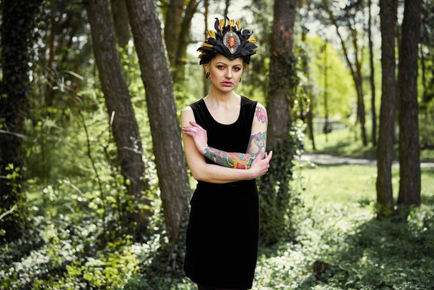 Gorgeous young woman in elegant headdress posing outdoors  - Valokuva, kuva