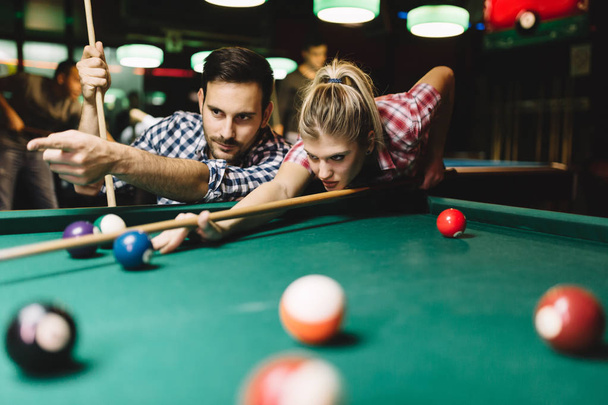 Young attractive couple playing snooker together in bar - Foto, Imagem