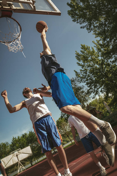 Street basketbal hráči, kteří hrají na hřišti v parku - Fotografie, Obrázek