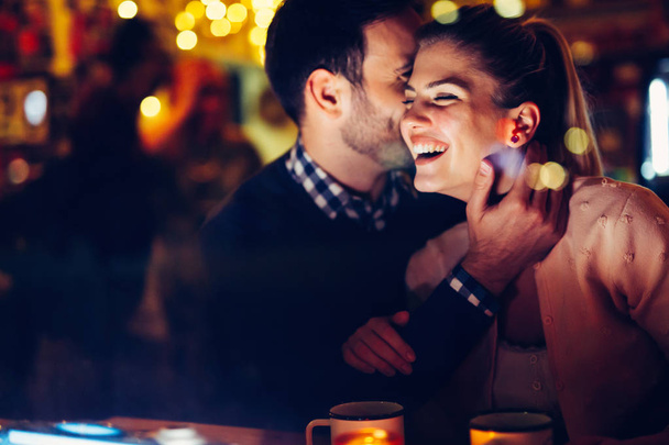 Romantic young couple dating in pub at night - Foto, Imagen
