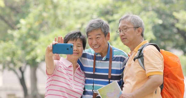 Vanhemmat ystävät matkustavat yhdessä ja ottavat selfien matkapuhelimella
 - Valokuva, kuva