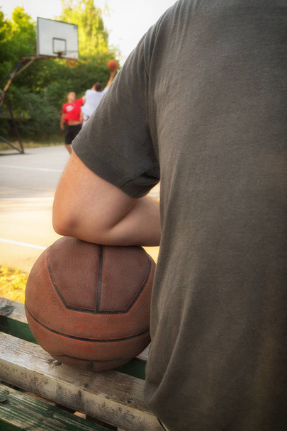 Μπάλα μπάσκετ και παίκτης με θολή σπορ παιδική χαρά. - Φωτογραφία, εικόνα