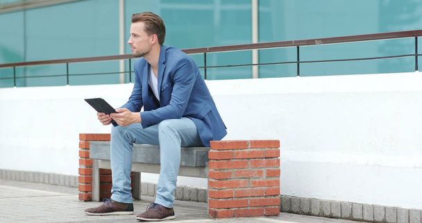Caucasian Businessman using tablet computer at outdoor - 写真・画像