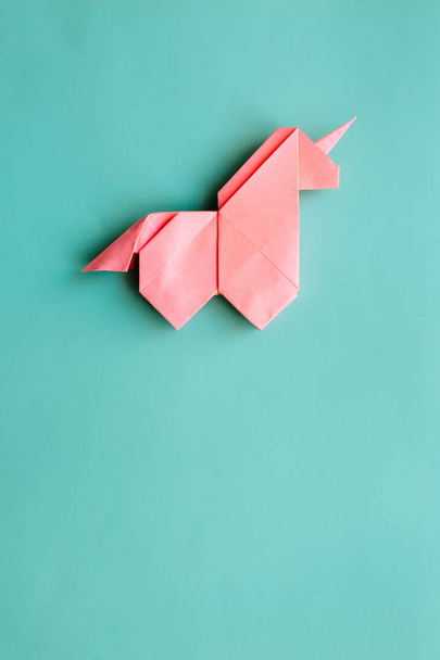 Unicorno di origami di carta poligonale geometrica di tendenza rosa fatto a mano su sfondo blu. Spazio vuoto. Manifesto verticale, cartolina, modello banner
. - Foto, immagini