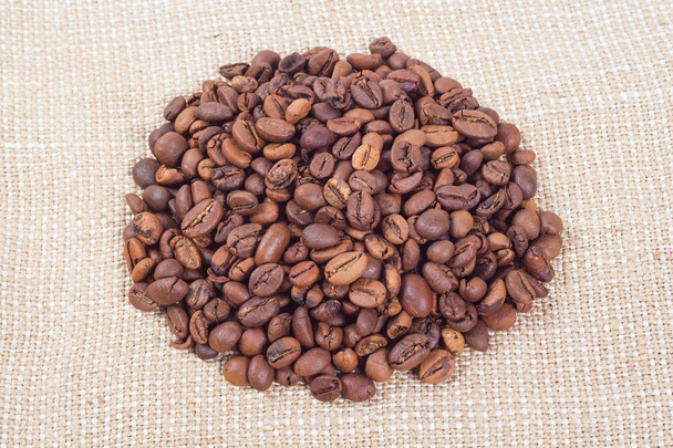 Heap of coffee beans on background of burlap - Photo, Image