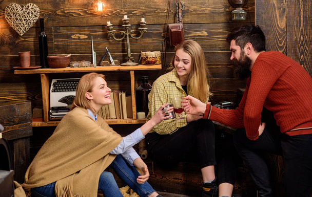 Company of friends celebrate with mulled wine in cozy atmosphere, wooden background. Man and ladies on cheerful faces have fun together. Cheers concept. Friends talking and celebrating with drinks - Fotó, kép
