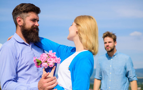 Leave past behind. Couple with bouquet romantic date. Ex husband jealous on background. Couple in love dating outdoor sunny day, sky background. Ex partner watching girl starts happy love relations - 写真・画像