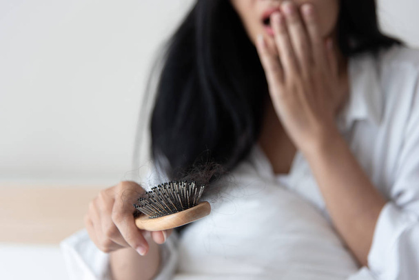 woman show her brush for presetation  hairloss problem and looking at her hair - Foto, Imagem