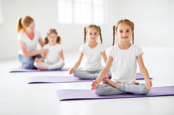 Übende Kinder betreiben Gymnastik und Yoga unter Anleitung - Foto, Bild