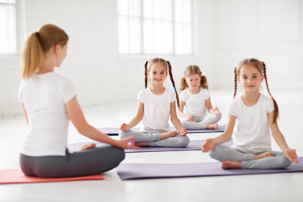 los niños que practican se dedican a la gimnasia y el yoga con teache
 - Foto, imagen