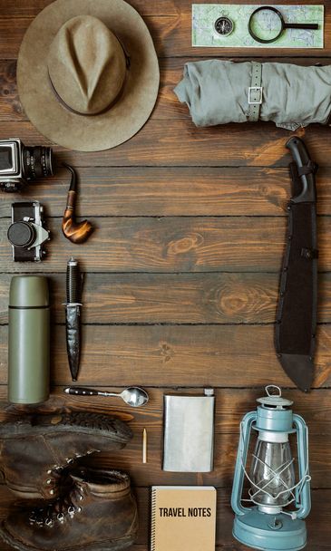 Camping gear including knife, clothes, boots, lantern, camera, hat, map, compass. Vertical wanderlust, safari postcard, poster, banner template. Room for text,copy, lettering. - Photo, Image