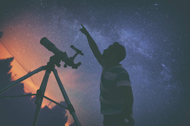 Молодой человек ночью использует телескоп
 - Фото, изображение
