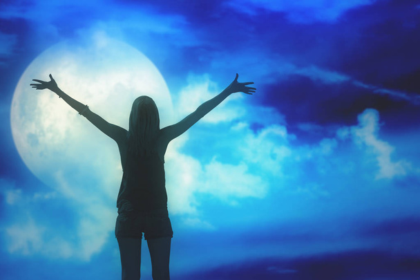 Silhouette di una ragazza con le mani in alto di notte
 - Foto, immagini