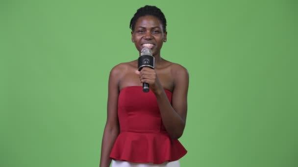 Young beautiful African woman using microphone - Πλάνα, βίντεο