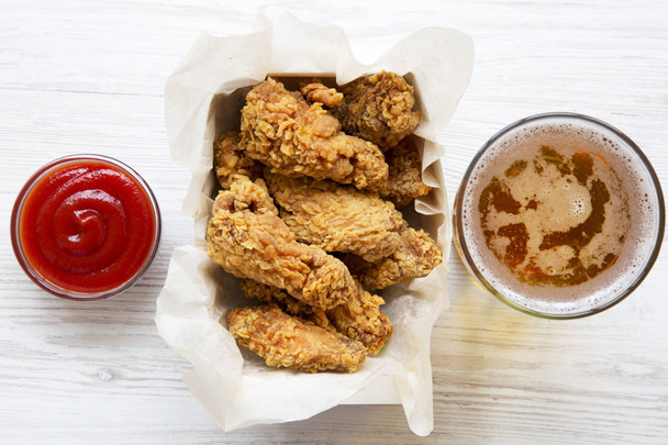 Tasty chicken wings with red pepper sauce, cold beer, from above. Flat lay, overhead. Closeup. - Zdjęcie, obraz