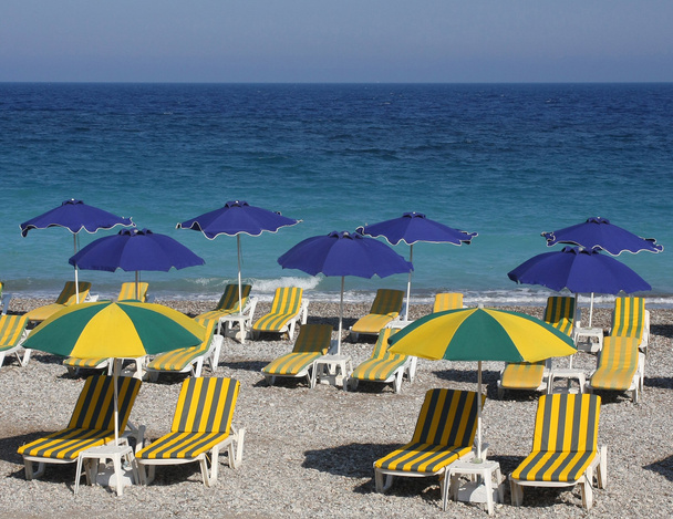 Strand mit Liegen und bunten Sonnenschirmen - Foto, Bild