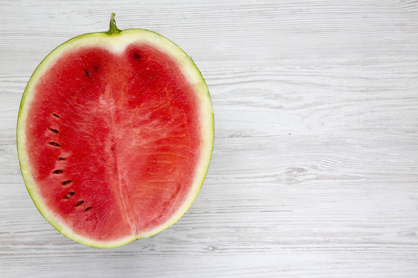 Pohled shora, poloviční broušená meloun na bílý dřevěný stůl. Z výše uvedeného. Kopírovat prostor. - Fotografie, Obrázek