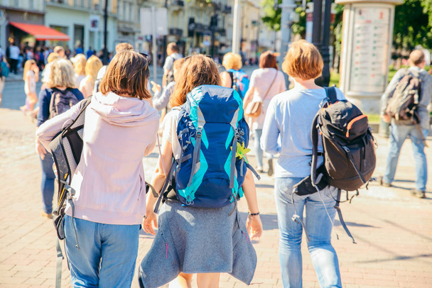 three young adult women walking by city streets with backpack. hikers in city - 写真・画像