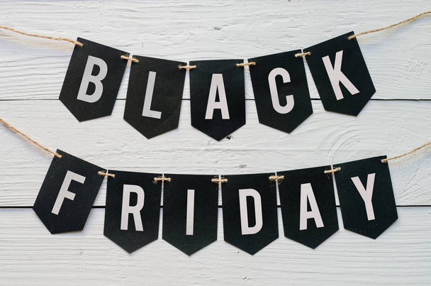 Black Friday paper banner garland lettering hanging on white barn wood planks background. Beautiful holiday flyer. - Fotografie, Obrázek