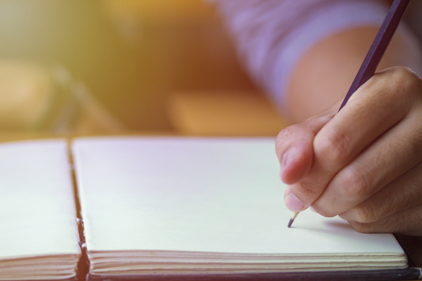 Επαγγελματίες αρσενικό χέρια με μολύβι γράφοντας στο σημειωματάριο εγγράφου. - Φωτογραφία, εικόνα