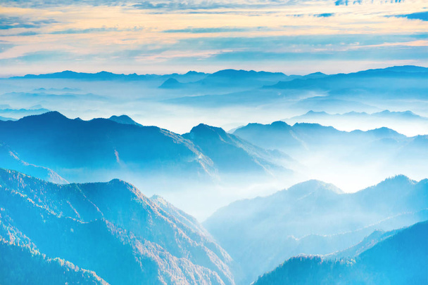 Landschaft mit Sonnenuntergang in blauen Bergen und Nebel - Foto, Bild