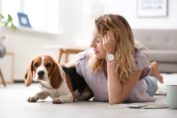 Young woman with her dog at home - Fotoğraf, Görsel