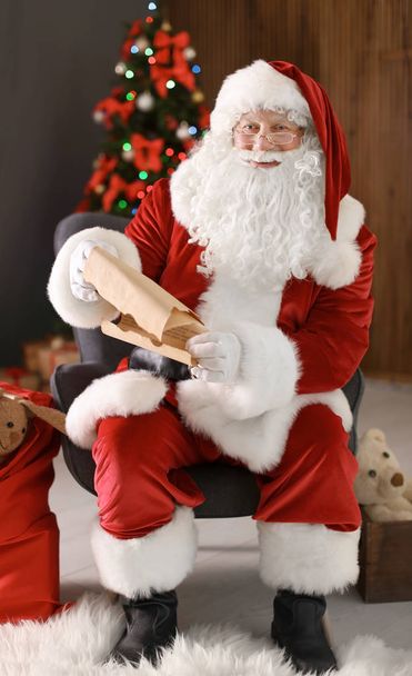 Authentic Santa Claus reading wish list indoors - Foto, imagen