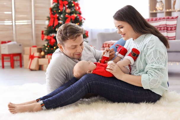 Happy couple with baby celebrating Christmas together at home - Фото, зображення