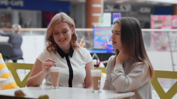 Mujeres jóvenes tomando café y comunicándose en la cafetería
. - Metraje, vídeo