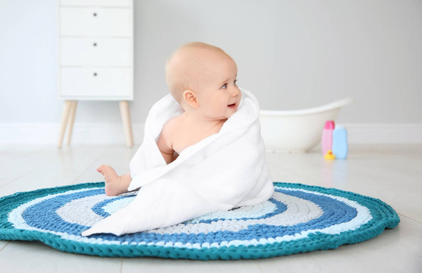 Cute little baby with soft towel on rug in bathroom - Foto, Bild