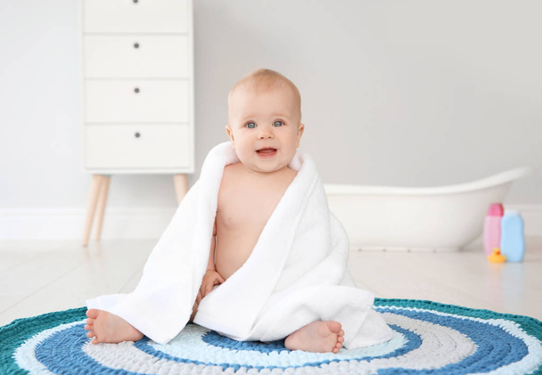 Cute little baby with soft towel on rug in bathroom - Φωτογραφία, εικόνα