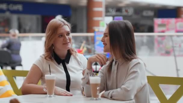 Mujeres jóvenes tomando café y comunicándose en la cafetería
. - Metraje, vídeo